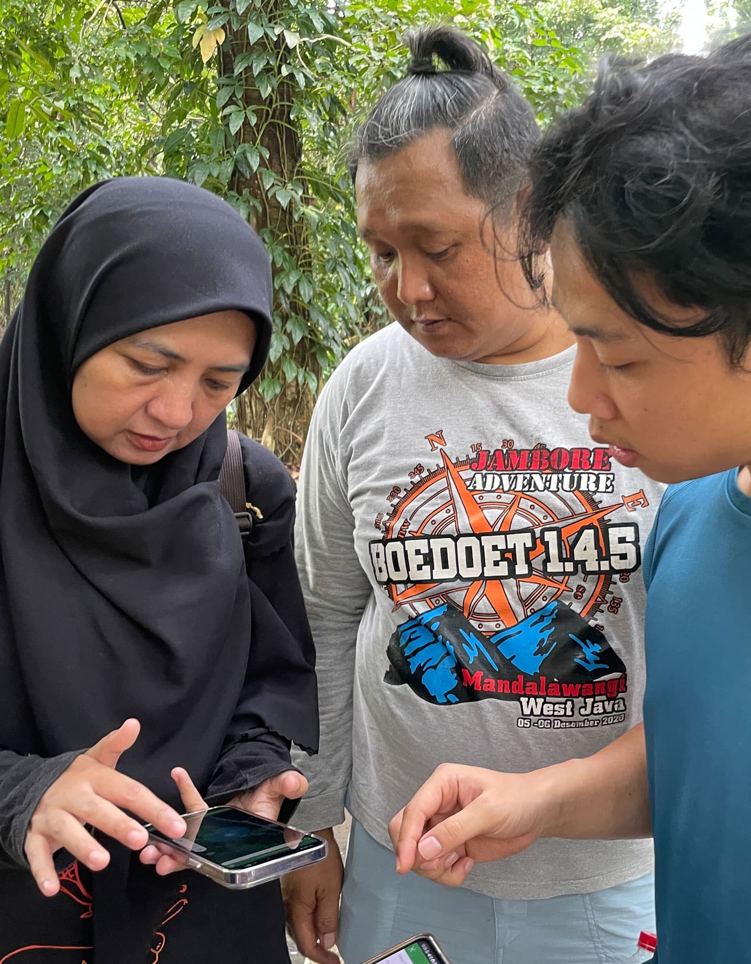 A woman and two men documenting
