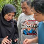 A woman and two men documenting